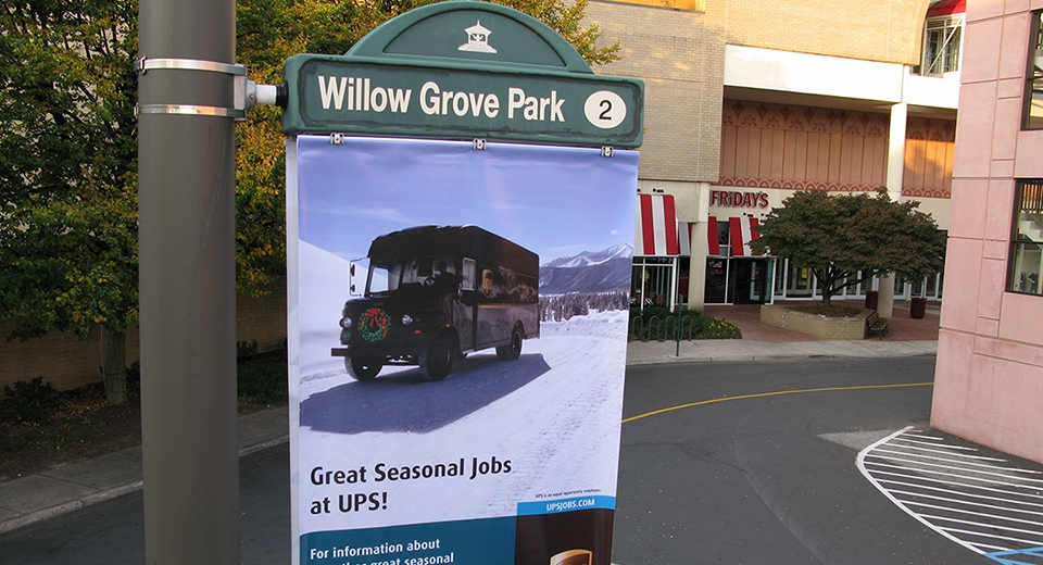 Up-close image of a Lumen Banner installed at Willow Grove Park. The banner displays an advertisement for UPS.