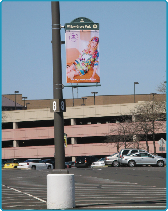 Lumen Banner displayed on a light pole in a parking lot vibrantly showing an advertisment.